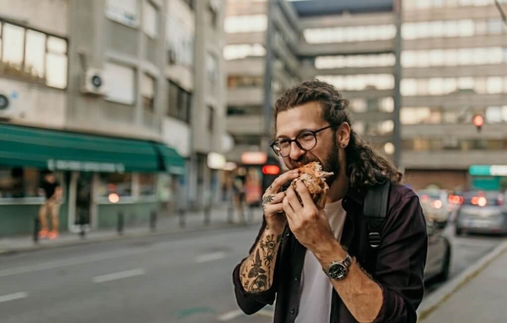 Man enjoying street food at a food stall.